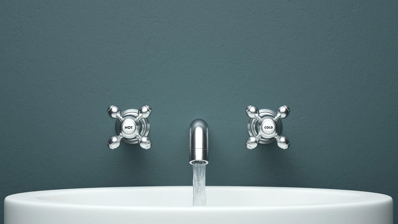 A close up of two faucets on the wall
